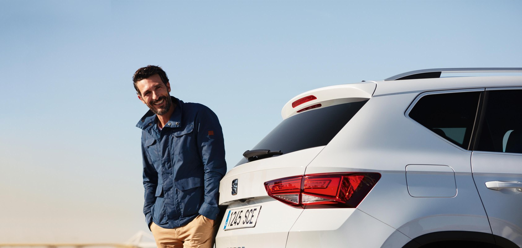SEAT new car services and maintenance – Man standing behind admiring the SUV SEAT Ateca