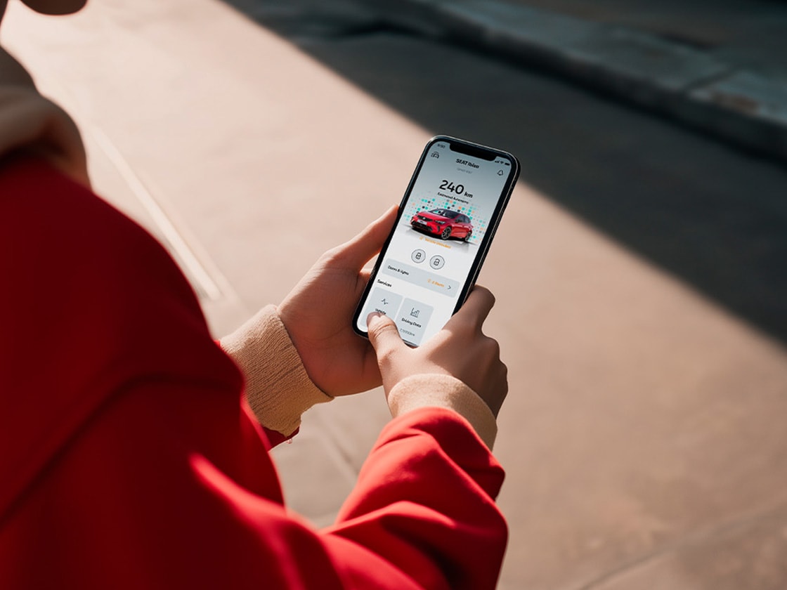 Person holding their smartphone using seat’s remote functions
