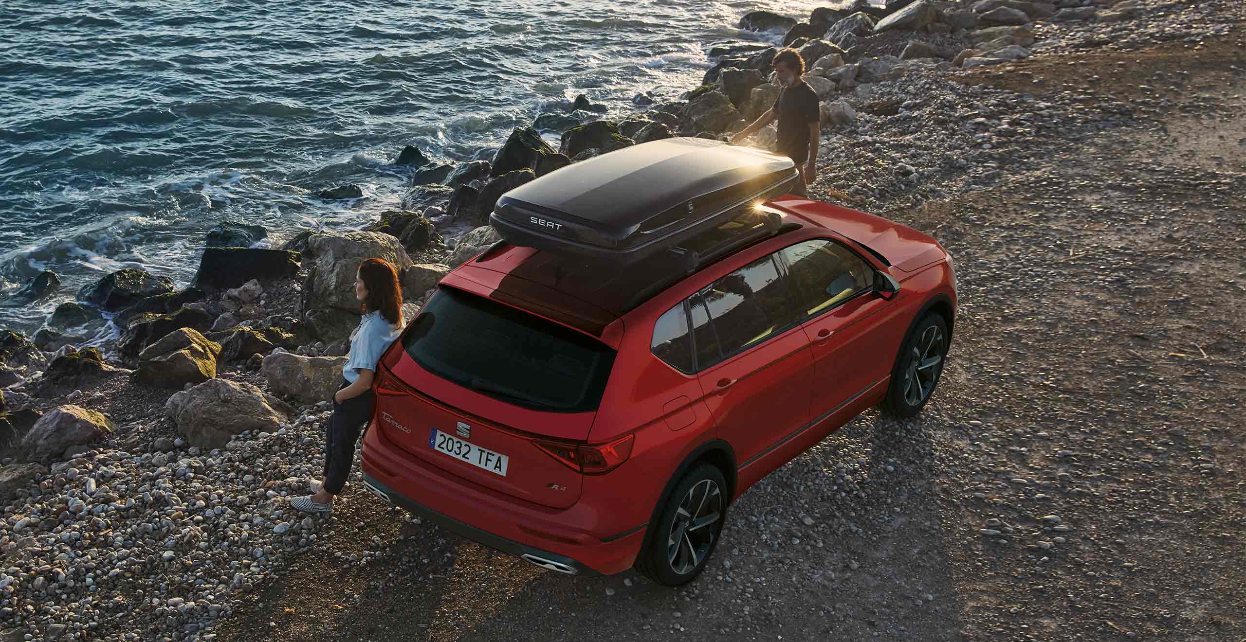 Woman lay on the new SEAT Tarraco SUV 7 seater merlot red colour with a roof box accessory