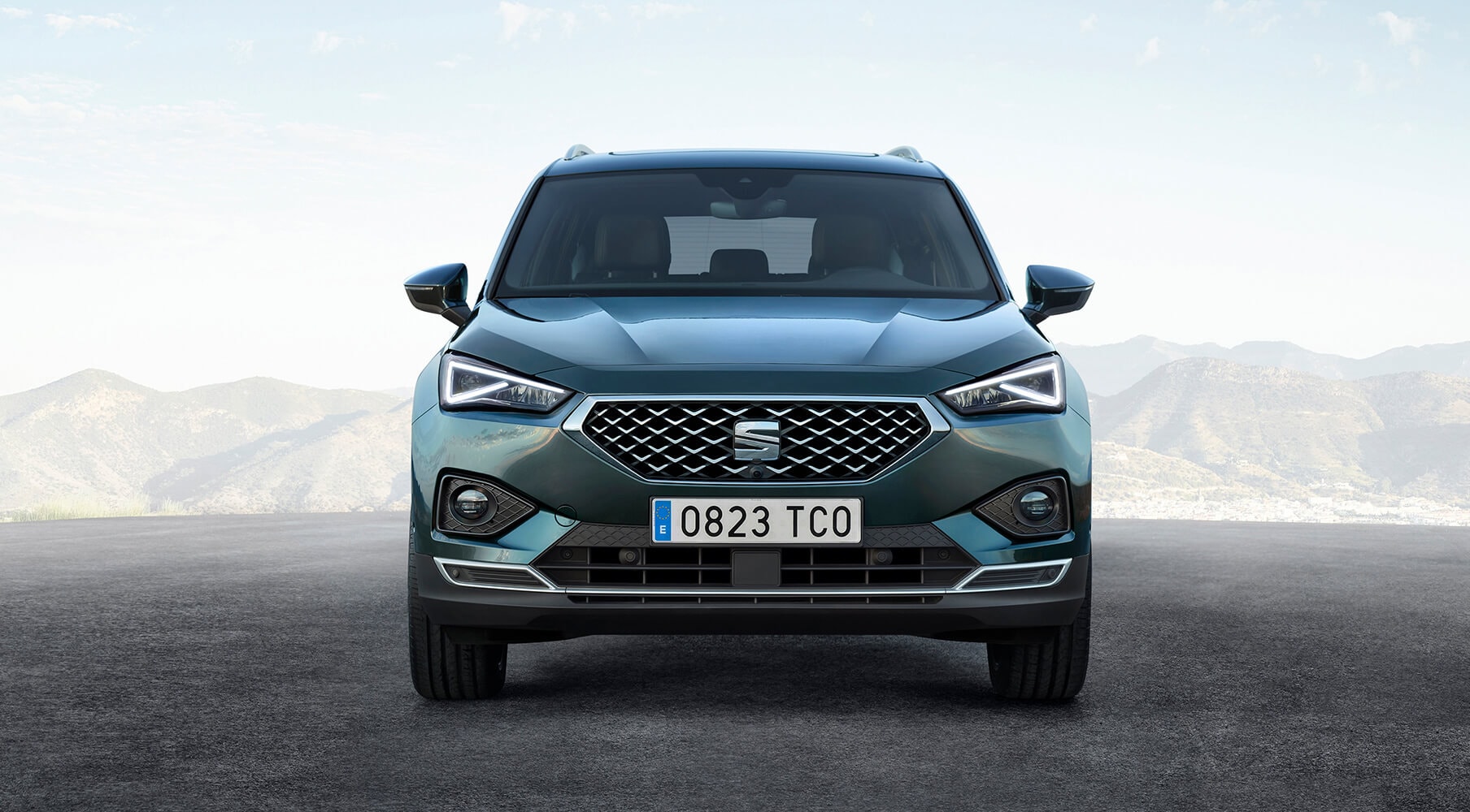 Presenting the new flagship model, SEAT Tarraco large SUV front part with mountains behind