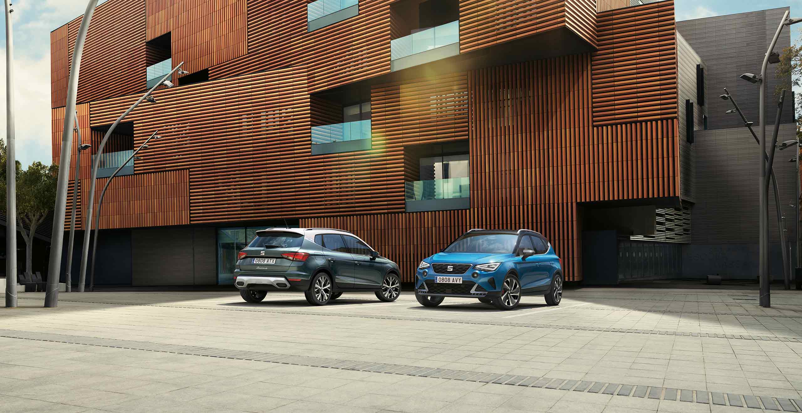 Two SEAT Arona parked, one dark camouflage colour and another Sapphire Blue colour 