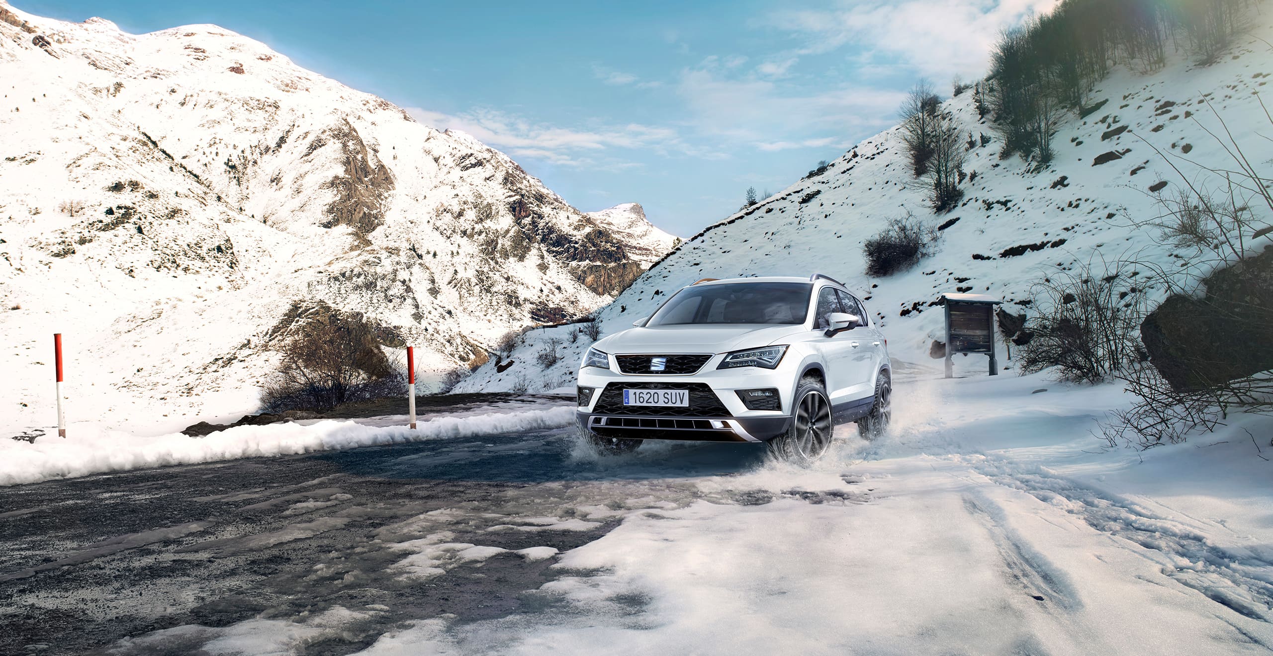 SEAT new car services and maintenance – exterior front action shot of a SEAT Ateca SUV in snowy mountains