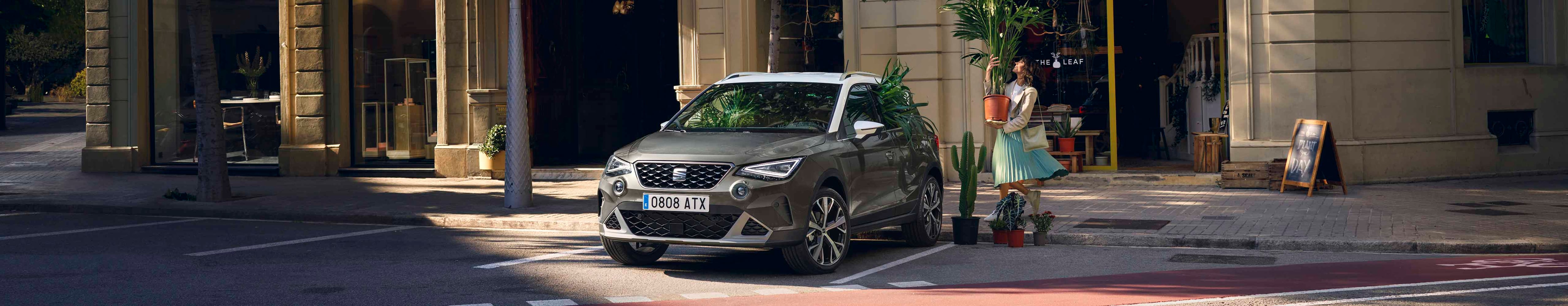 Woman walking to SEAT Arona dark camouflage colour