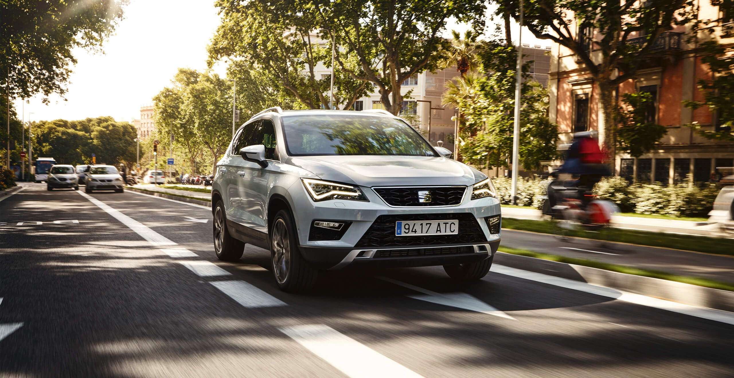SEAT new car services and maintenance two year warranty – SEAT Ateca SUV driving on a road beside trees